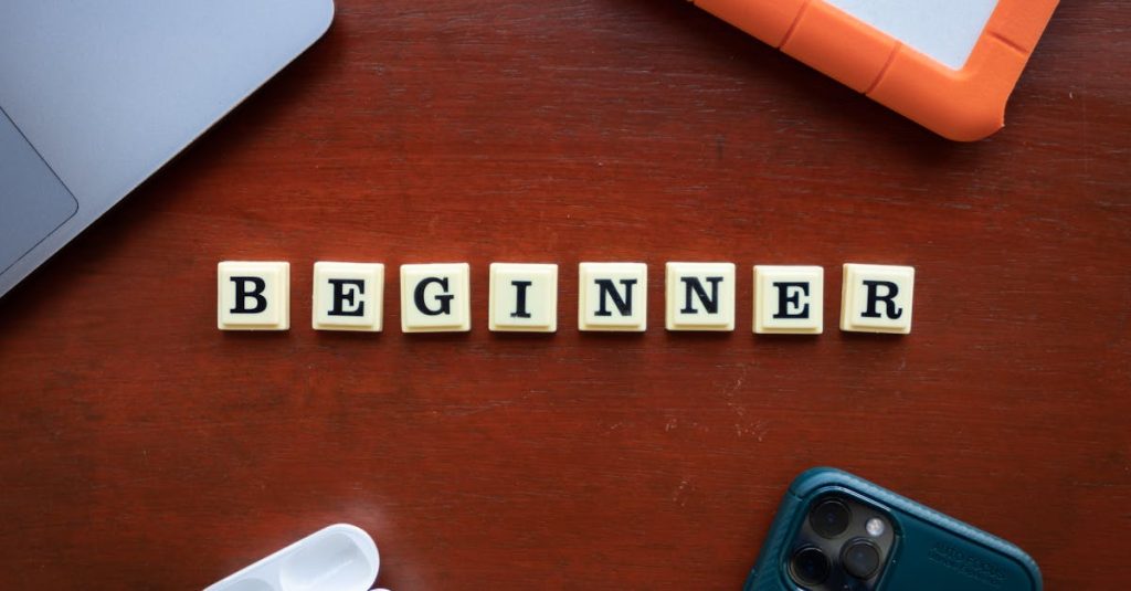 A top view of beginner workspace items including gadgets and letter dice on a wooden desk.